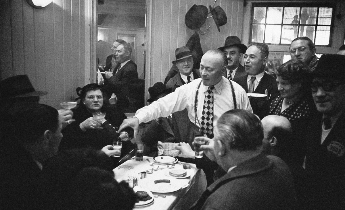 A Jewish man shares a bottle of champagne with friends in Whitechapel, then the center of the Jewish community in London, April 1952. Photo by John Chillingworth/Picture Post/Hulton Archive/Getty Images.
