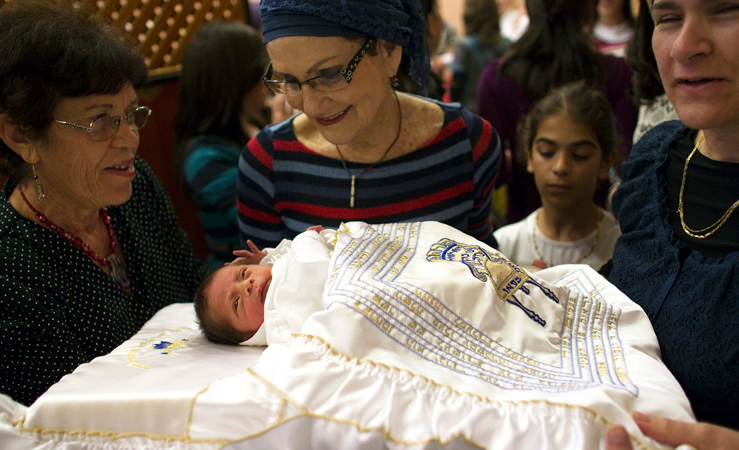 
A baby and relatives after his circumcision. REUTERS/Ronen Zvulun.

