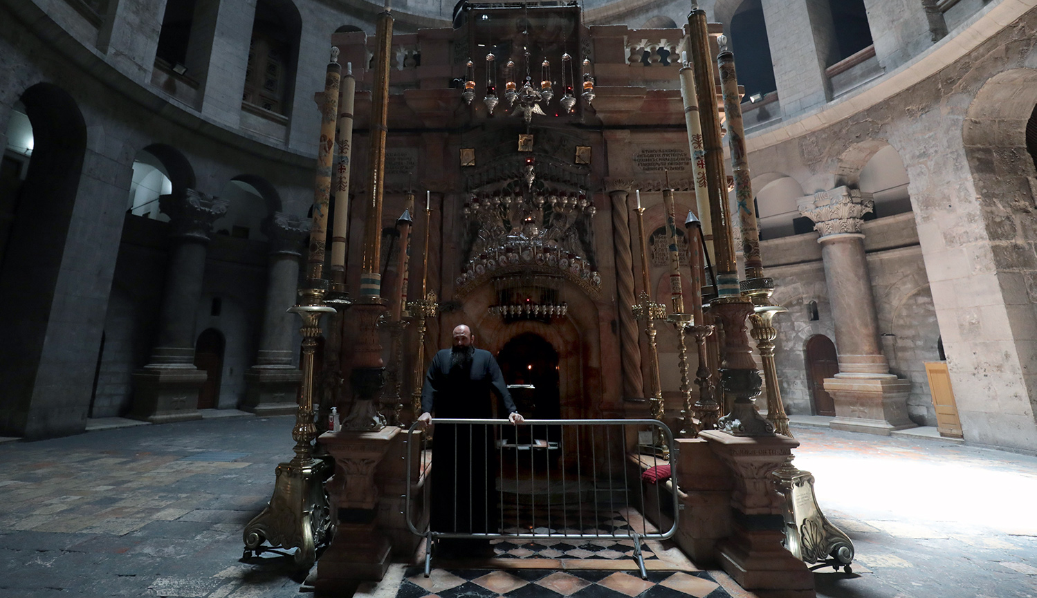 A Greek Orthodox monk stands behind a barricade at the entrance of the Edicule in the Church of the Holy Sepulchre, on May 26, 2020. GALI TIBBON/AFP via Getty Images.
