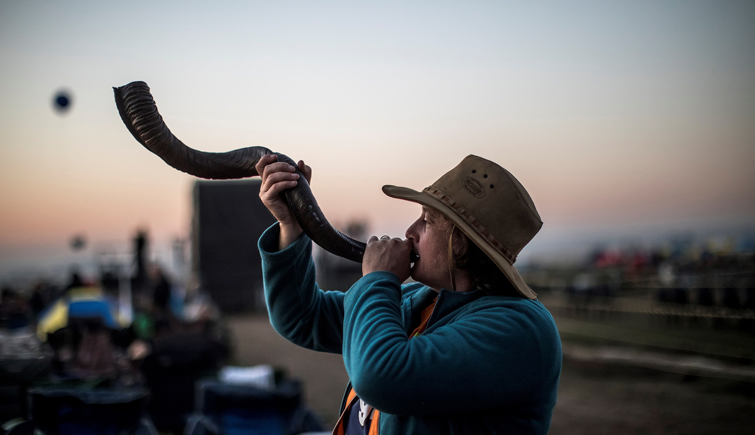A follower of South African Christian revival evangelist Angus Buchan blows a shofar at an informal airfield outside Pretoria on October 27, 2018. MARCO LONGARI/AFP via Getty Images.
