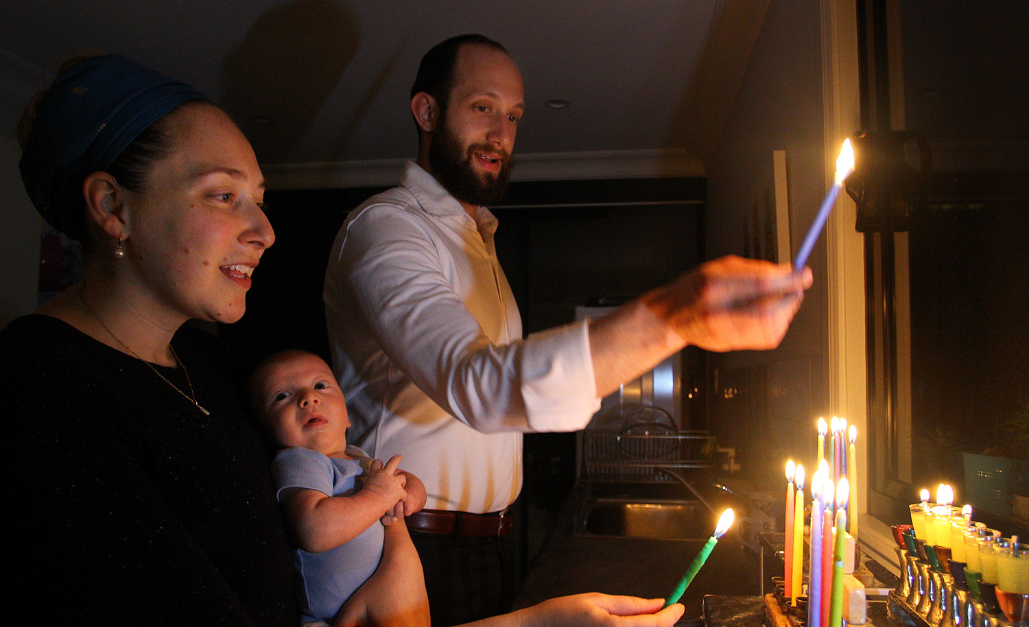 A family light their menorah at home on December 15, 2020 in Sydney, Australia. Lisa Maree Williams/Getty Images.
