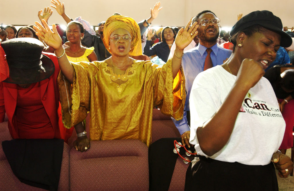 Nigerian Christians pray together at the City of David Church in Lagos, Nigeria, on September 28, 2003. Photo by Jacob Silberberg via Getty Images.
