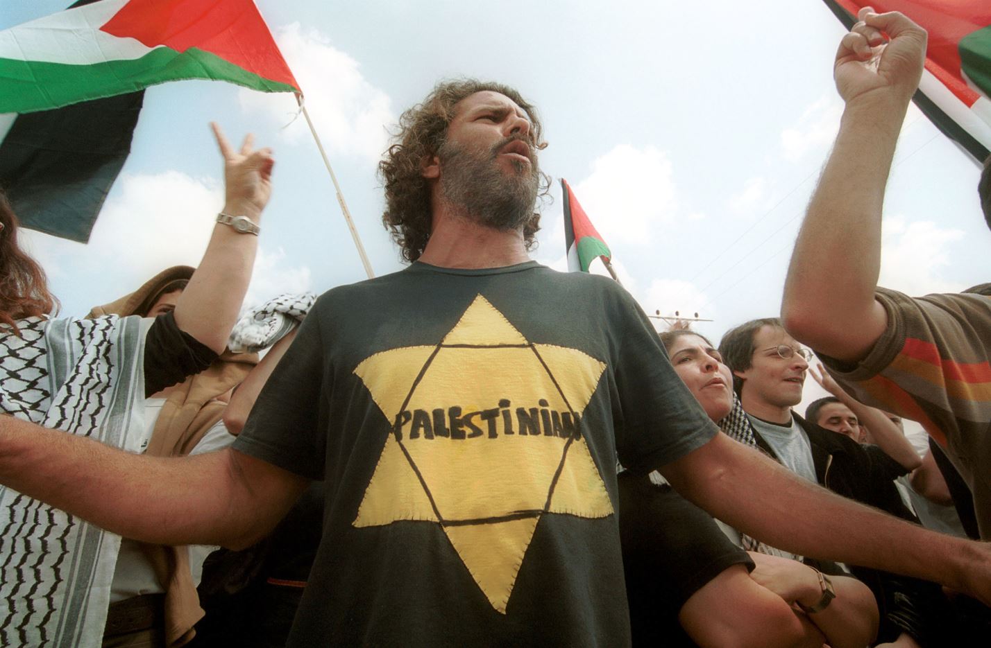 An man wears a yellow Star of David shirt with &#8220;Palestinian&#8221; written inside it while protesting at an Israeli checkpoint on April 9, 2002 near Jenin. Photo by Quique Kierszenbaum via Getty Images.
