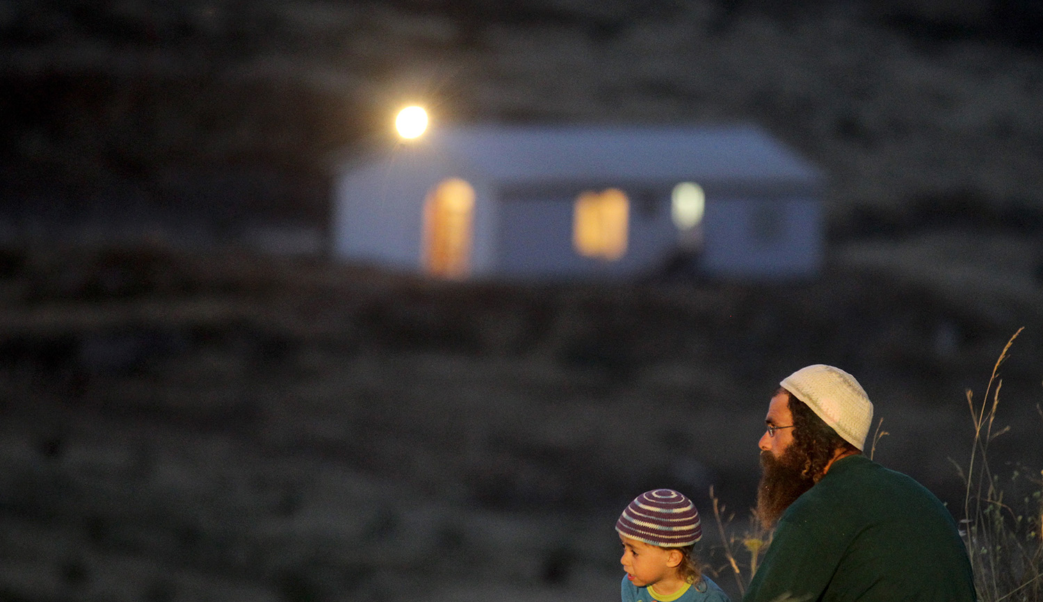 



A religious father and his son sit near the Havat Gilad settlement on May 28, 2012. Nati Shohat/Flash90.




