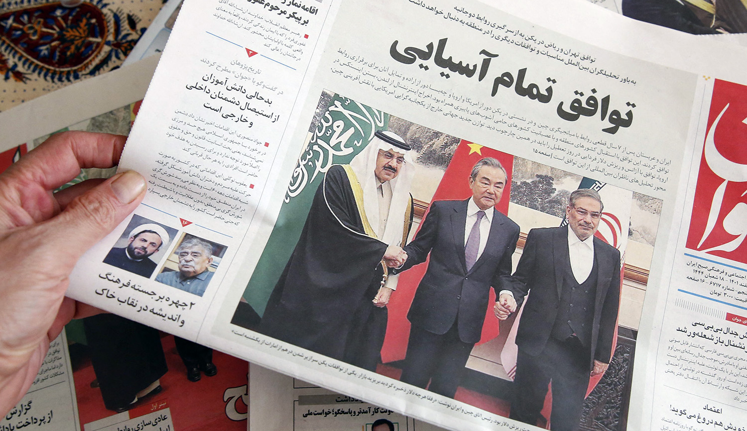 
A man in Tehran holds a newspaper reporting the China-brokered deal between Iran and Saudi Arabia to restore ties, signed in Beijing the previous day, on March, 11 2023. ATTA KENARE/AFP via Getty Images.






