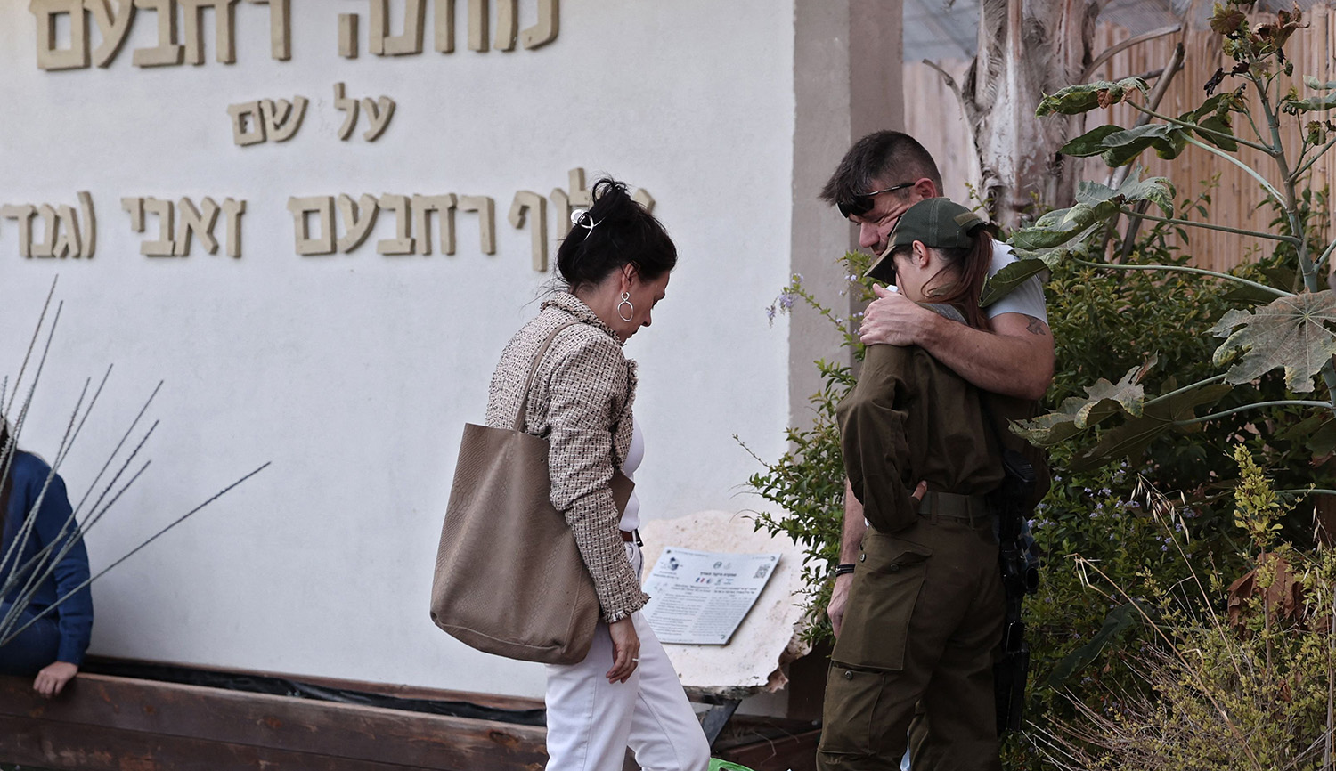 An Israeli soldier hugs her parents before returning to military service on October 15, 2023. THOMAS COEX/AFP via Getty Images.
