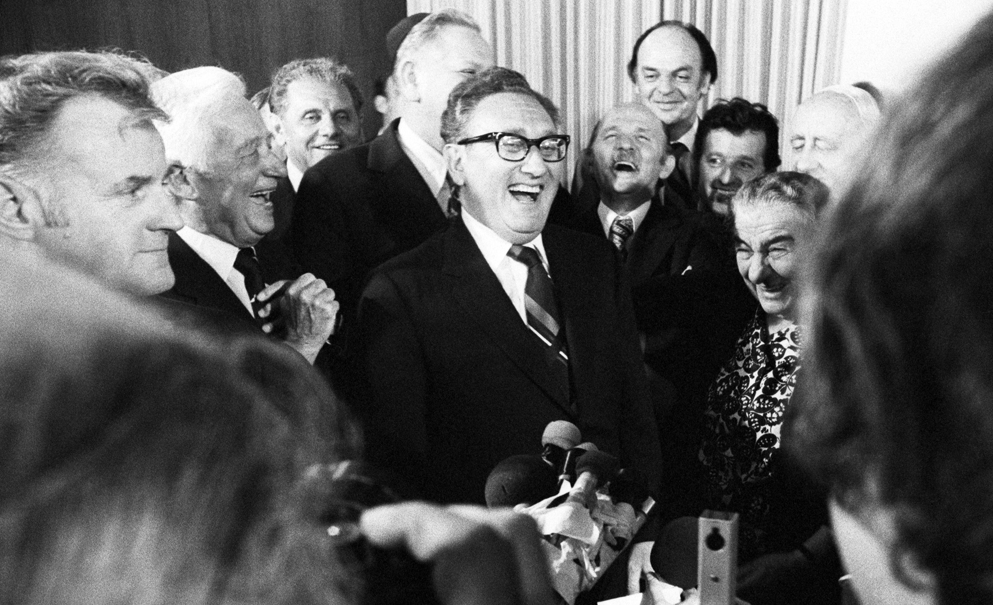 U.S. Secretary of State Henry Kissinger, Israeli Prime Minister Golda Meir, and other Israeli cabinet ministers roar with laughter after she had been kissed by Kissinger at a party May 29th, 1974. Bettmann/Getty.
