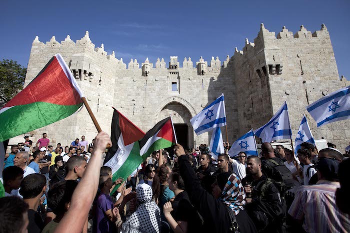 Israelis and Palestinians wave flags as Israelis march celebrating Jerusalem Day outside Damascus Gate in Jerusalem's old city on Wednesday, May 8, 2013. Credit: Associated Press/Sebastian Scheiner.